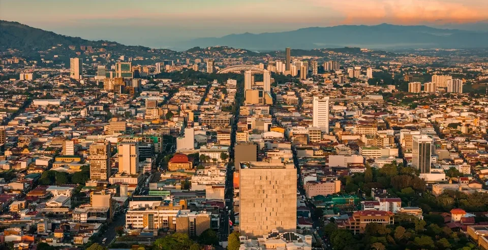 Image of Aerial View Of San José Cityscape During Sunrise with text overlay of "Cost of Living in Costa Rica: Expat Guide"